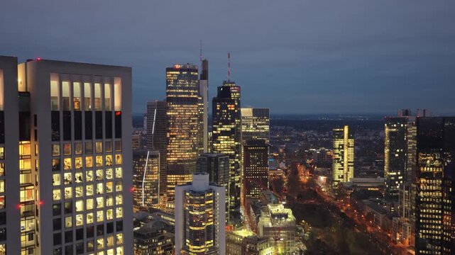 Frankfurt's skyline illuminating city after sunset. Iconic skyscrapers of financial and banking district glittering in the dark