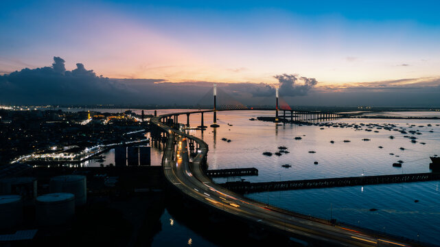 Aerial view of the Cebu-Cordova Link Expressway (CCLEX) bridge cutting through the deep blue waters, with the city lights twinkling like stars, Cebu City, Central Visayas, Philippines.