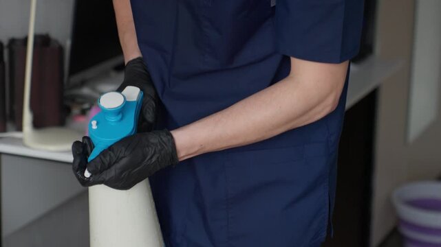 Caucasian Technician Cleaning Inside Sofa Cavity With Focused Sprayer, Undercushion Sanitation, Closeup Of Nozzle And Wood Frame, Gloves And Careful Insertion, Discrete Interior Work
