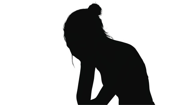 Black silhouette of a sad female figure with hair in a bun resting her head on her hand against white.