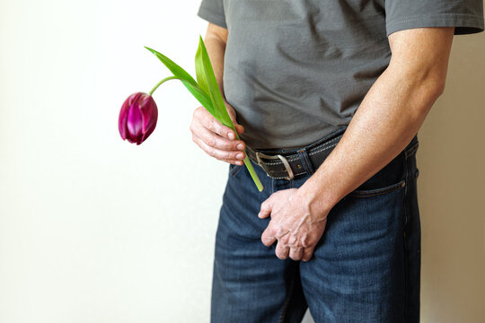 Erectile dysfunction concept. Man holding a flower bending downwards.