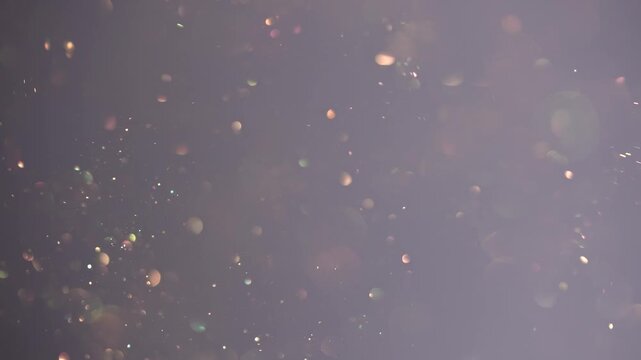 Soft blurred bokeh lights float against a gradient peach and gray background. Concept for overlay, holiday, events industries, beauty and cosmetics, branding, digital design, advertising and wallpaper