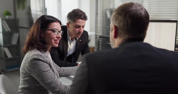 Analysts coworkers team meeting for data analysis. Managers review a spreadsheet on a computer in a finance office. Calm tone suits audit and advice. Finance accuracy and client trust concept.