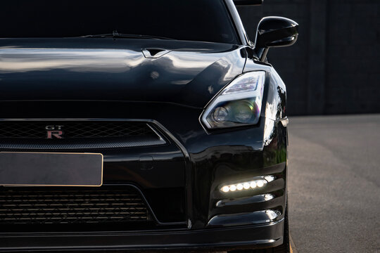 Black Nissan GT-R front half close up, High performance sports car external shot outdoors