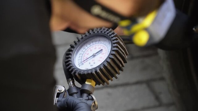 Man driver hand inflating tires. Fill Air station service for vehicle tires. Checking air pressure car wheels maintenance and safety. Mechanic inflating put air into the tyre, checking air pressure. 