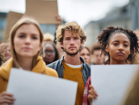 Young Activists at ProtestGroup of diverse young people holding blank placards at a public demonstration, showcasing unity and determination for a cause in an urban setting.protest