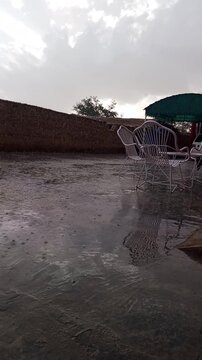 Cinematic rain falling on a quiet street in Quetta, Pakistan, moody weather landscape.