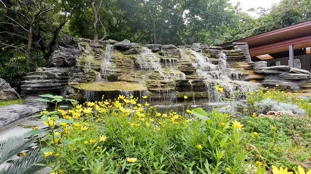 the rock formations and flowing water resemble a natural waterfall, but the area was created within the park to provide a beautiful, refreshing, and relaxing experience for tourists.