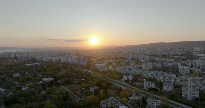 Drone shot Chaika neighborhood Varna Bulgaria sunset light. Cityscape residential buildings urban architecture sea horizon background. Summer evening aerial perspective