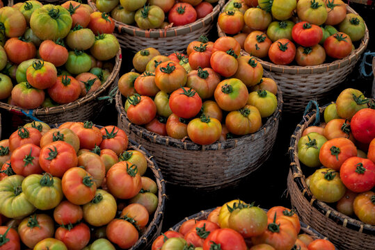 View of baskets overflowing with vibrant tomatoes in a colorful display of fresh produce, a feast for the eyes and taste buds, Sylhet, Sylhet Division, Bangladesh.