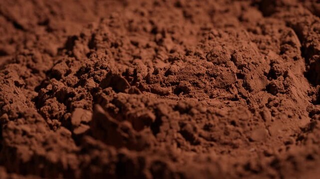 Natural dark brown cocoa powder textured background, close up, rotation. Heap of organic cacao powder