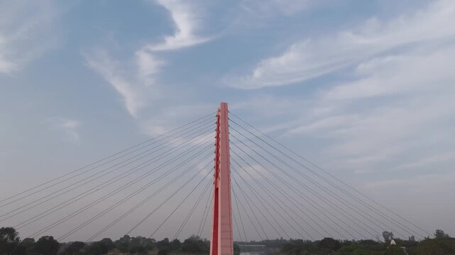 Aerial view of Laxman Jhula bridge at Tola Ghat, Drone shot of suspension bridge over river at Tola Ghat, Scenic view of Laxman Jhula with river landscape, Tola Ghat suspension bridge over calm water.