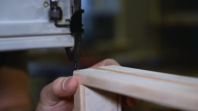 Master uses a pneumatic hammer to fasten the wooden planks, work with pneumatic tool, production of furniture and interior items, carpentry in the workshop.