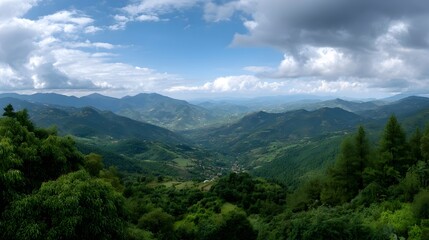 Fototapeta premium Panoramic vista of a lush green valley nestled between rolling mountains under a dramatic sky with scattered clouds