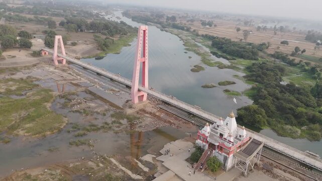 Aerial view Tola Ghat Patan bridge over river Chhattisgarh, Drone shot Tola Ghat Patan suspension bridge and temple, Scenic river crossing at Tola Ghat Patan India aerial stock video.