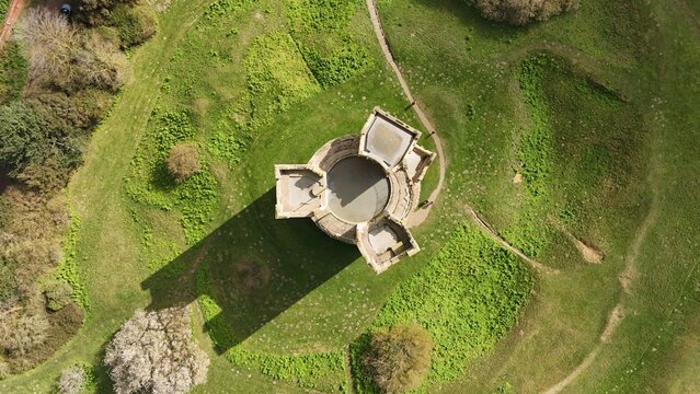Aerial view of the castle keep standing proudly amidst a sea of green grass, its stone walls casting long shadows, Orford Castle, Orford, United Kingdom.