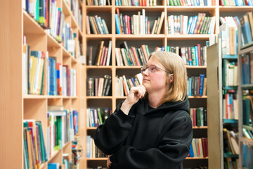 Young man browsing bookshelves in library