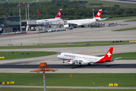 Titel: Helvetic Airways passenger airplane Embraer E190LR registration HB-JVM landing at Swiss Z&uuml;rich Airport on a late summer day. Photo taken September 15th, 2025, Zurich Airport, Switzerland.