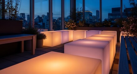 Obraz premium Rooftop lounge with illuminated cubic seating and city backdrop at dusk