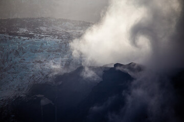 Fototapeta premium Spiraling clouds over blue ice glacier in Thorsmork Iceland artistic nature