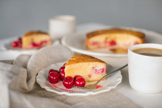 Close-up of a sugar free low carb cherry and strawberry cake made with coconut and almond flour on a table with two cups of white coffee
