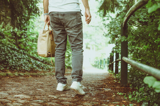 Rear view of a Man in jeans walking in a park on a summer day, Luxembourg
