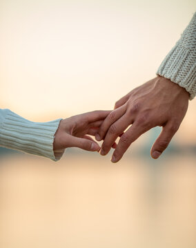 Couple holding hands at sunset.