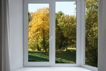 Fototapeta premium Window frame with view on green, yellow landscape,park trees, autumn forest.