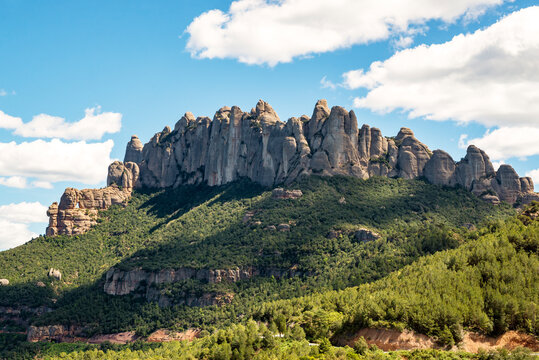 Dramatic rocky landscape surrounded by lush forest, Montserrat Mountain Range Natural Park, Barcelona, Catalonia, Spain