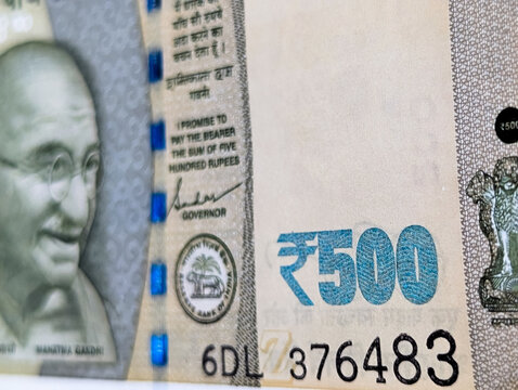 Close up shot of Indian five hundred rupees banknote showing Mahatma Gandhi portrait and serial number