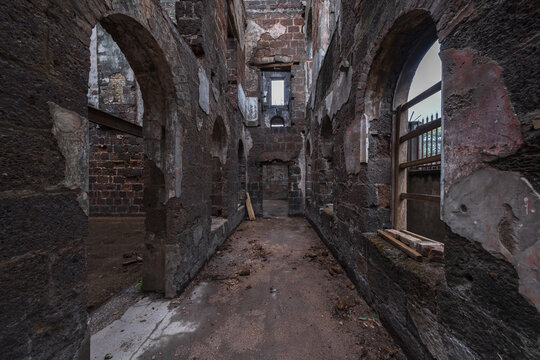 View of the interior of a ruined historic building with arched stone doorways and weathered brick walls in Freetown, Western Area, Sierra Leone.