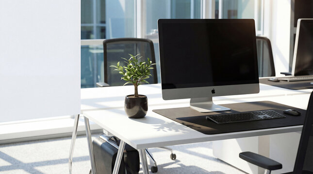 Photograph of a minimalist modern office desk with a blank computer screen and small plant.