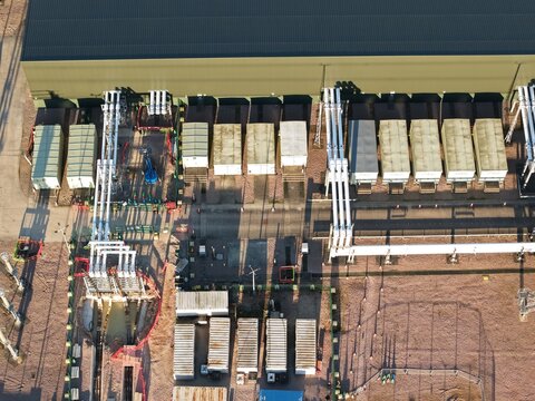 Aerial view of National Grid Bramford Substation's battery energy storage facility, where orderly rows of containers meet the textured ground, Ipswich, United Kingdom.