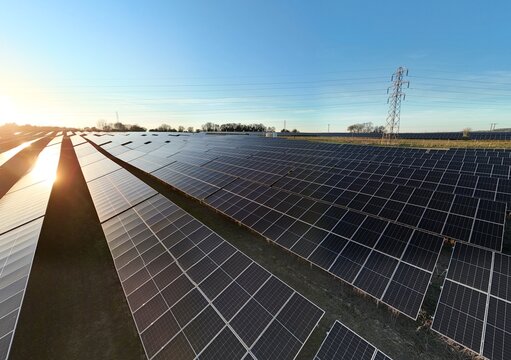 Aerial view of solar panels gleaming under the sun's golden rays, contrasting against the earth tones of the landscape, Tye Lane, Ipswich, United Kingdom.