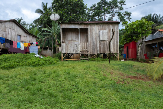 View of traditional wooden houses on stilts surrounded by lush tropical vegetation and green grass Sao Tome and Principe.