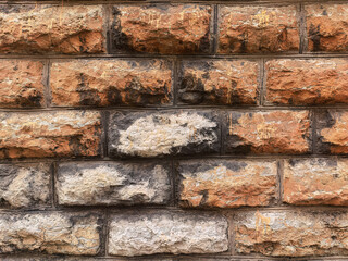 Fototapeta premium Full-frame background of an ancient stone wall made of rough-cut blocks.