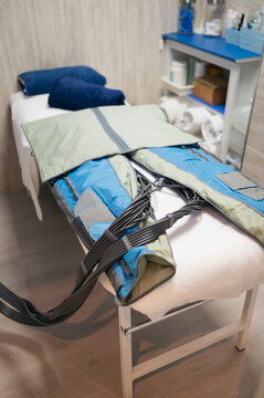 Pressotherapy bodysuit for lymphatic drainage treatment on a clinic bed