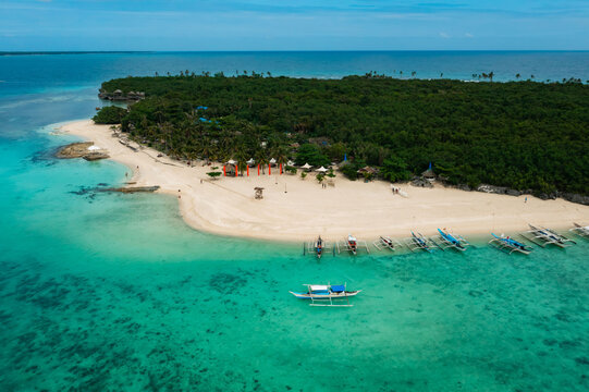 Aerial view of a lush tropical island fringed with pristine white sand beaches and turquoise waters, Virgin Island, Bantayan, Cebu, Philippines.