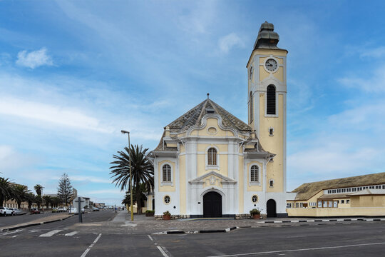View of the German Evangelical Lutheran Church with its yellow facade and clock tower under a blue sky in Swakopmund, Erongo Region, Namibia.