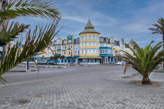 View of the colorful colonial-style architecture and palm trees along a paved street in Swakopmund, Erongo Region, Namibia.