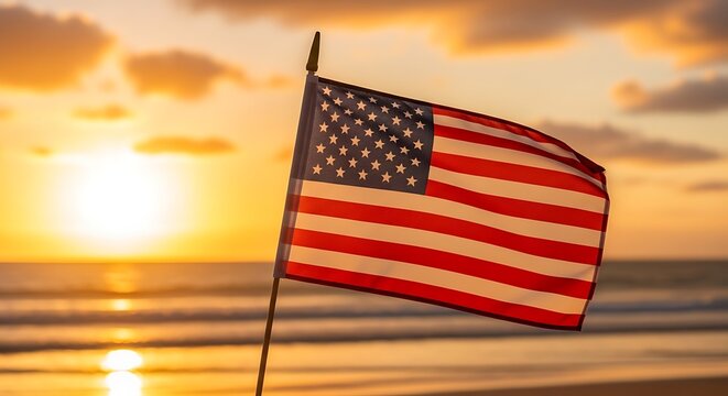 American flag waving on independence day at sunset beach