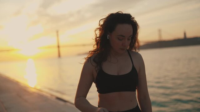 Athletic woman walking at sunset on a beautiful promenade