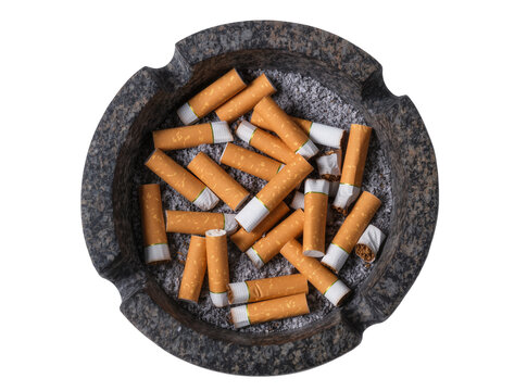 Isolated dark stone ashtray filled with numerous smoked cigarette butts and ash.
