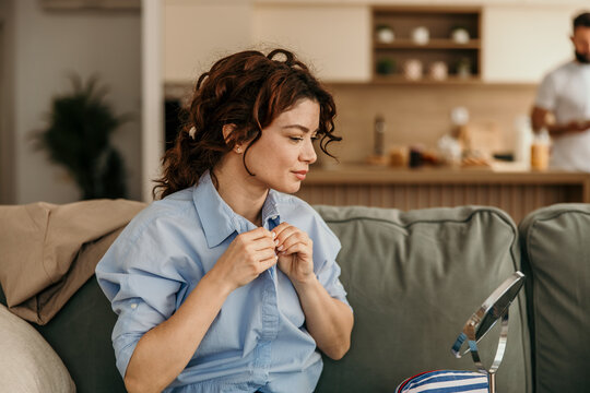 Young woman dressing blue shirt for daily morning routine