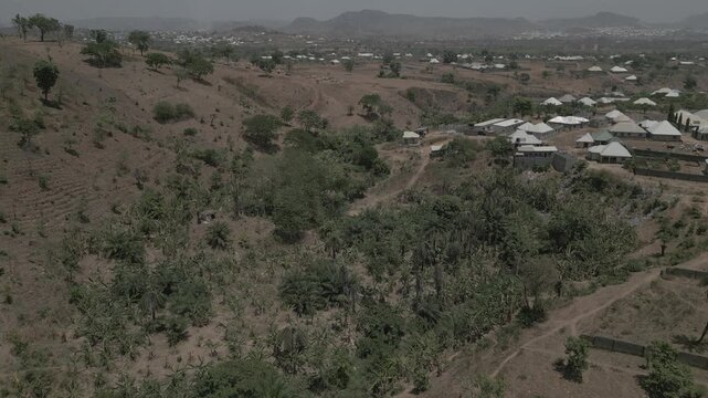 4K aerial video of a rural community in Kubwa, Bwari Area Council, Abuja, Nigeria, showcasing the intersection between residential areas and surrounding forest landscapes. 