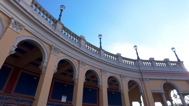 Classical Colonnade with Stone Arches and Balustrade Under Blue Sky