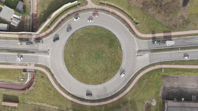 Genk, Belgium. Top-down drone hoovering over busy roundabout with flowing traffic and transport vehicles