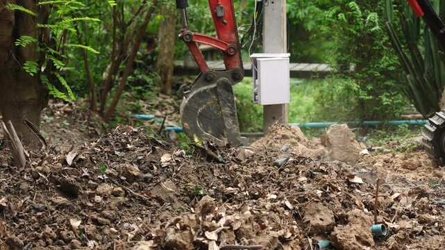 Excavator construction soil dirt outdoor machinery digging road repair work scene green tree shade with industrial digging work equipment and excavation earth dirt track vehicle for road repair work