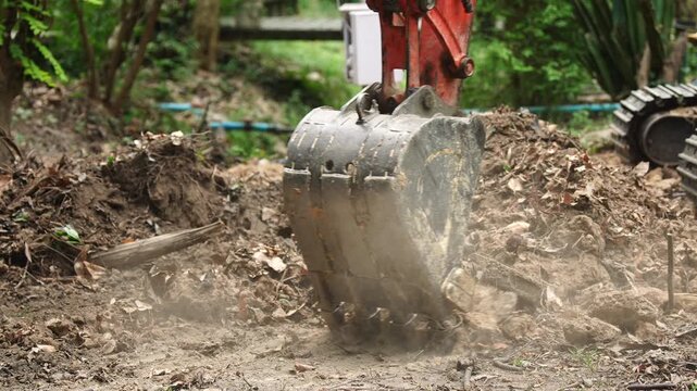 Excavator construction soil dirt earth ground pile debris landscape outdoor excavation digging soil and dirt earthmoving ground pile debris outdoor landscape near garden foliage heavy machinery