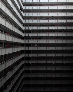 View of the repetitive geometric balconies and symmetrical architecture of a high-rise residential building in Hong Kong.